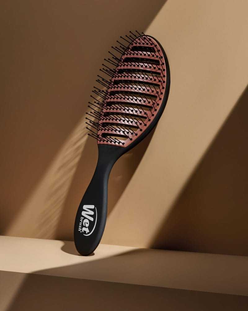 Wet Brush with brown bristles and black handle against a beige background.