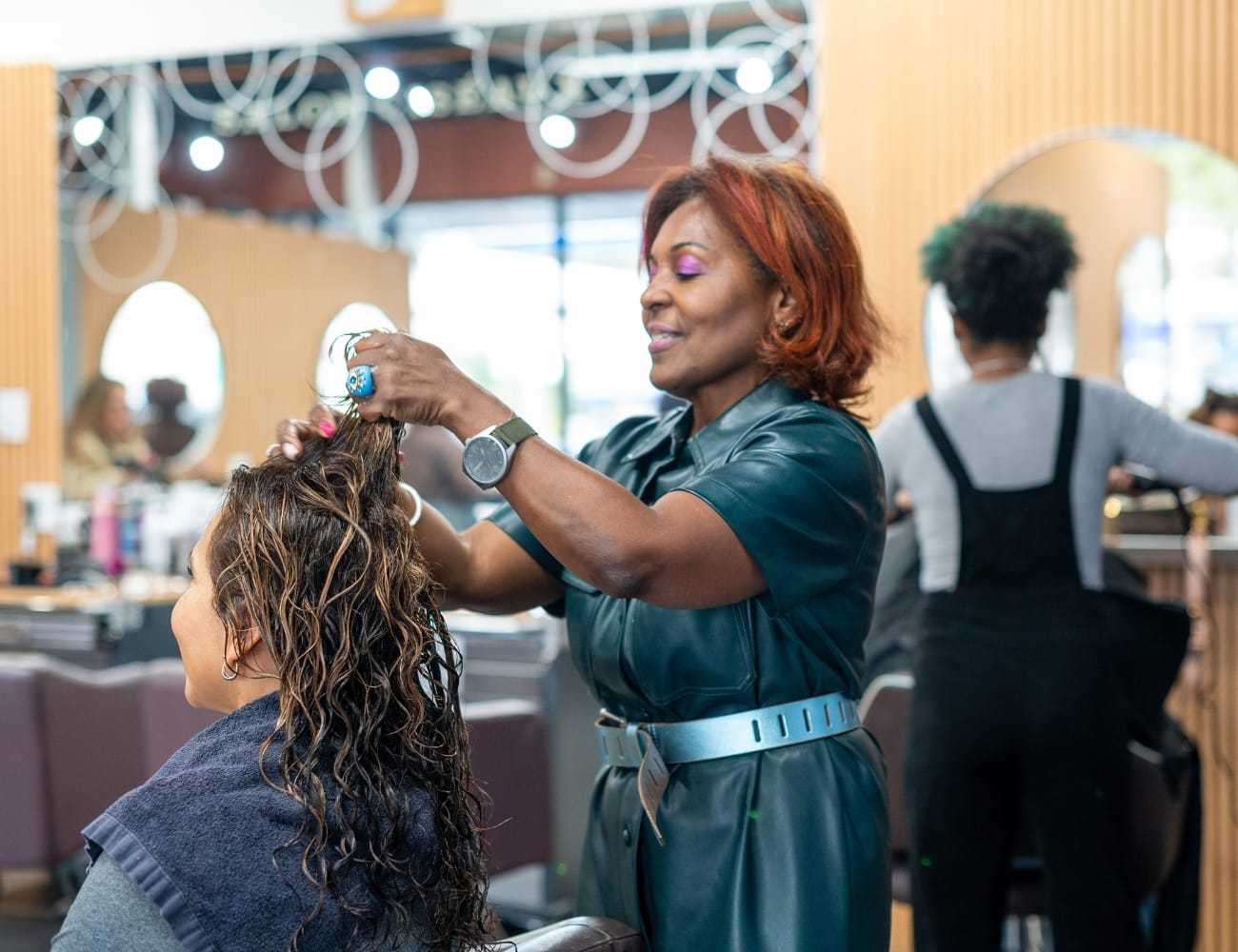 Hairstylist working on a client's hair in a modern salon setting.